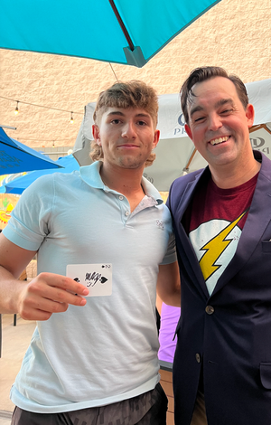 A senior poses for a photo with Adam Stone, holding a card