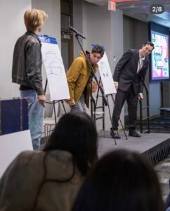 Adam Stone College Event Drawing Duplication Performance Adam Stone Magic mentalist Adam Stone on Stage at a College Event with Two Student Participants During a Drawing Duplication Effect