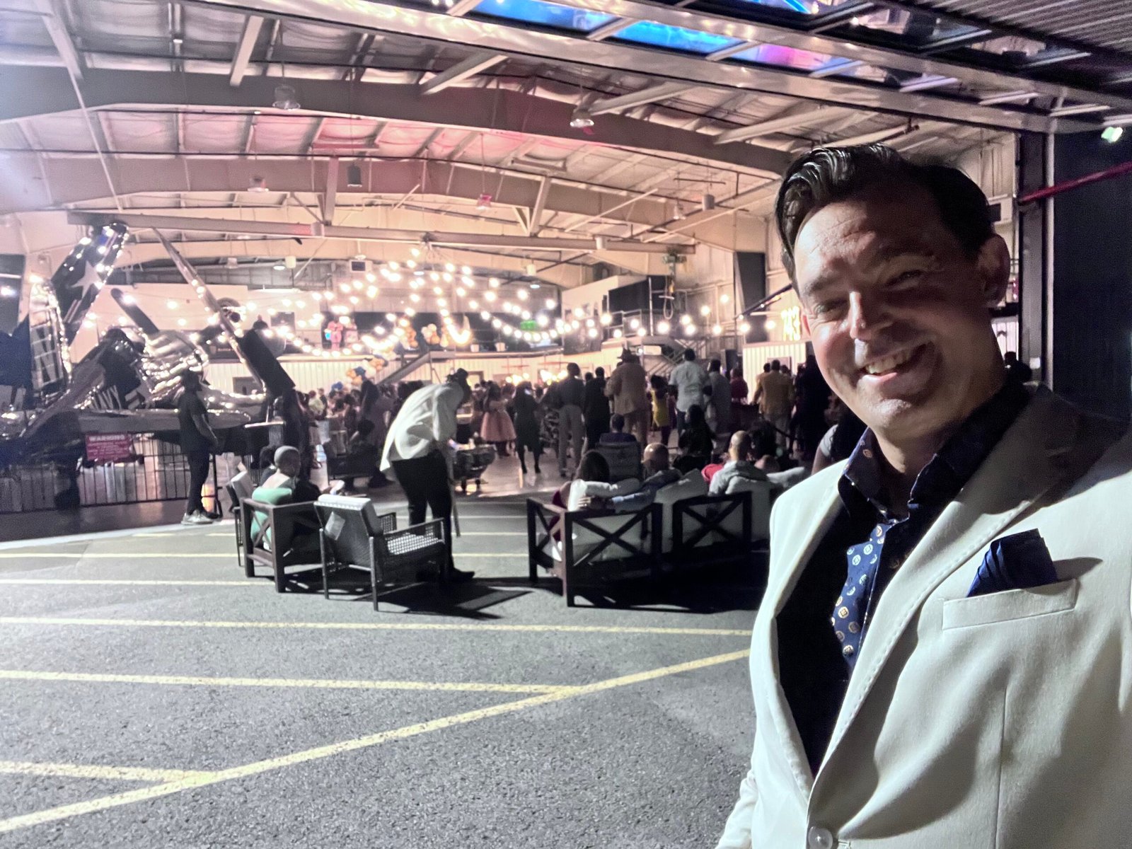 Adam Stone Fraternity Event Airport Hangar Performance Adam Stone Magic Adam Stone Magic Mentalist Adam Stone Standing in Front of an Airport Hangar at a Fraternity Event