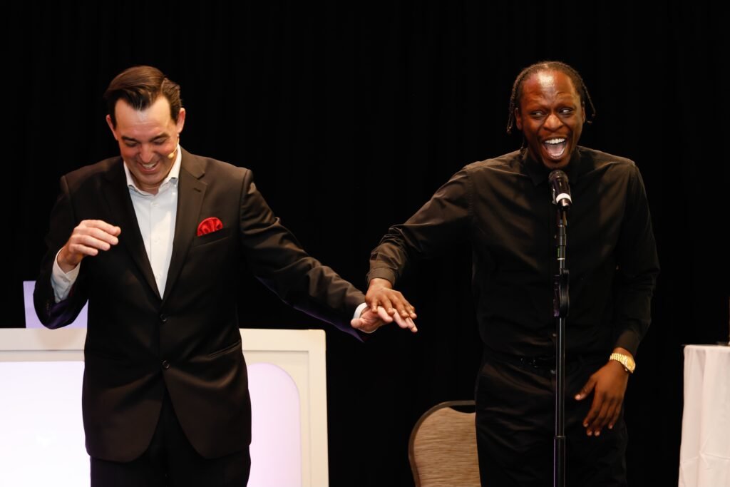 Adam Stone Corporate Event Mind Reading Performance Adam Stone Magic Adam Stone Magic Mentalist Adam Stone on Stage at a Corporate Event Reading a Spectatoraposs Mind As He Concentrates on a Specific Date His Hand Hovering over Adamaposs