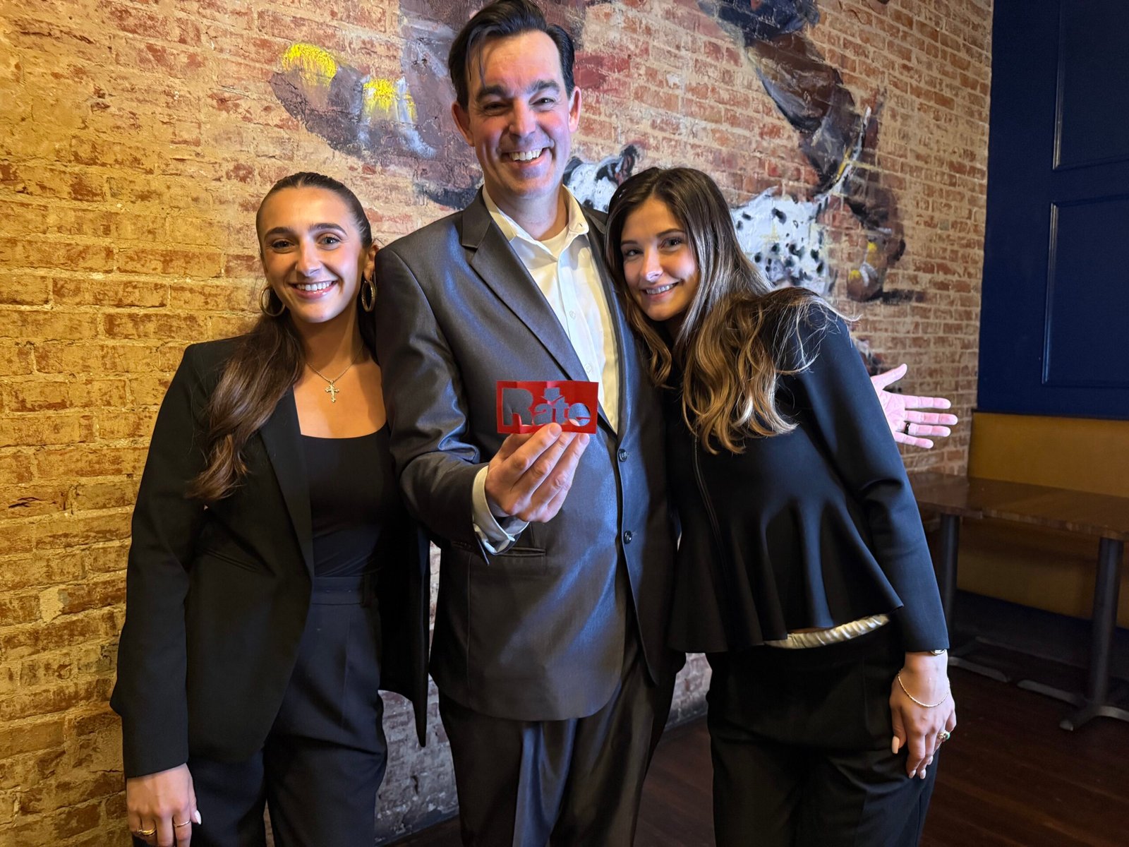 Corporate Mentalist Adam Stone Performing Strolling Close Up Magic for Two Guests at a Ropes and Gray Washington Dc Event Creating a Paper Cut of the Company Logo