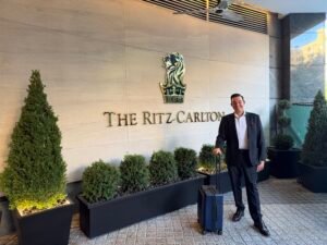 Corporate Mentalist Adam Stone Outside the Ritz carlton Washington Dc with His Suit Coat over His Shoulder and Strolling Case in Hand on a Summer Evening Before Performing for the Mid atlantic Shoulder and Elbow Society