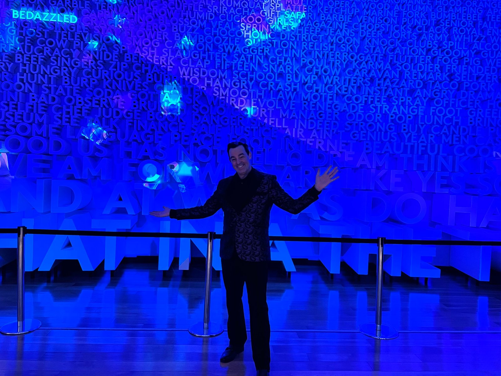 Corporate Mentalist Adam Stone Inside the Planet Word Museum in Washington Dc Surrounded by Words Projected on the Walls with Moving Spotlights Highlighting Different Words Throughout the Exhibit